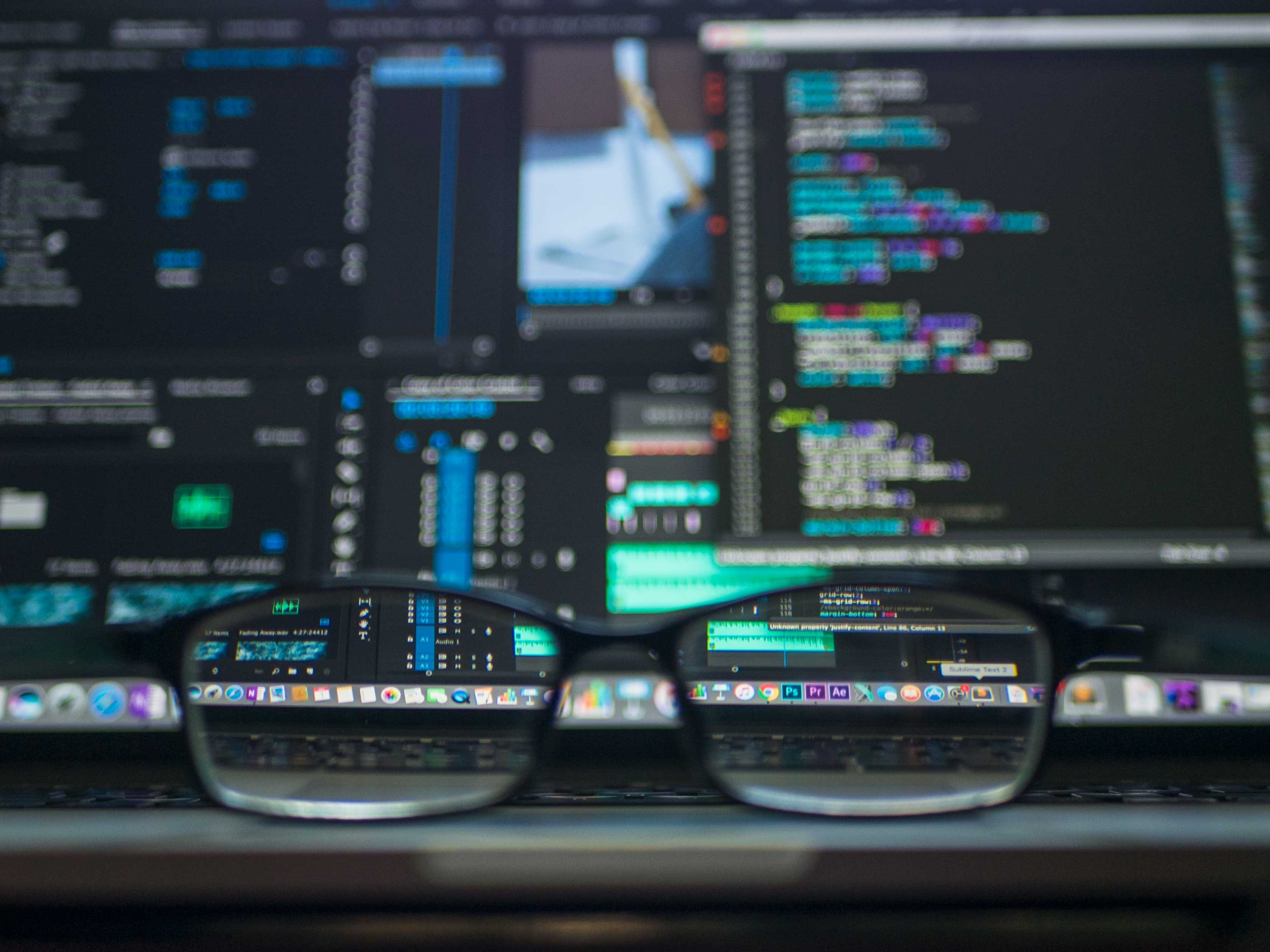 glasses are placed in front of a computer with lines of code