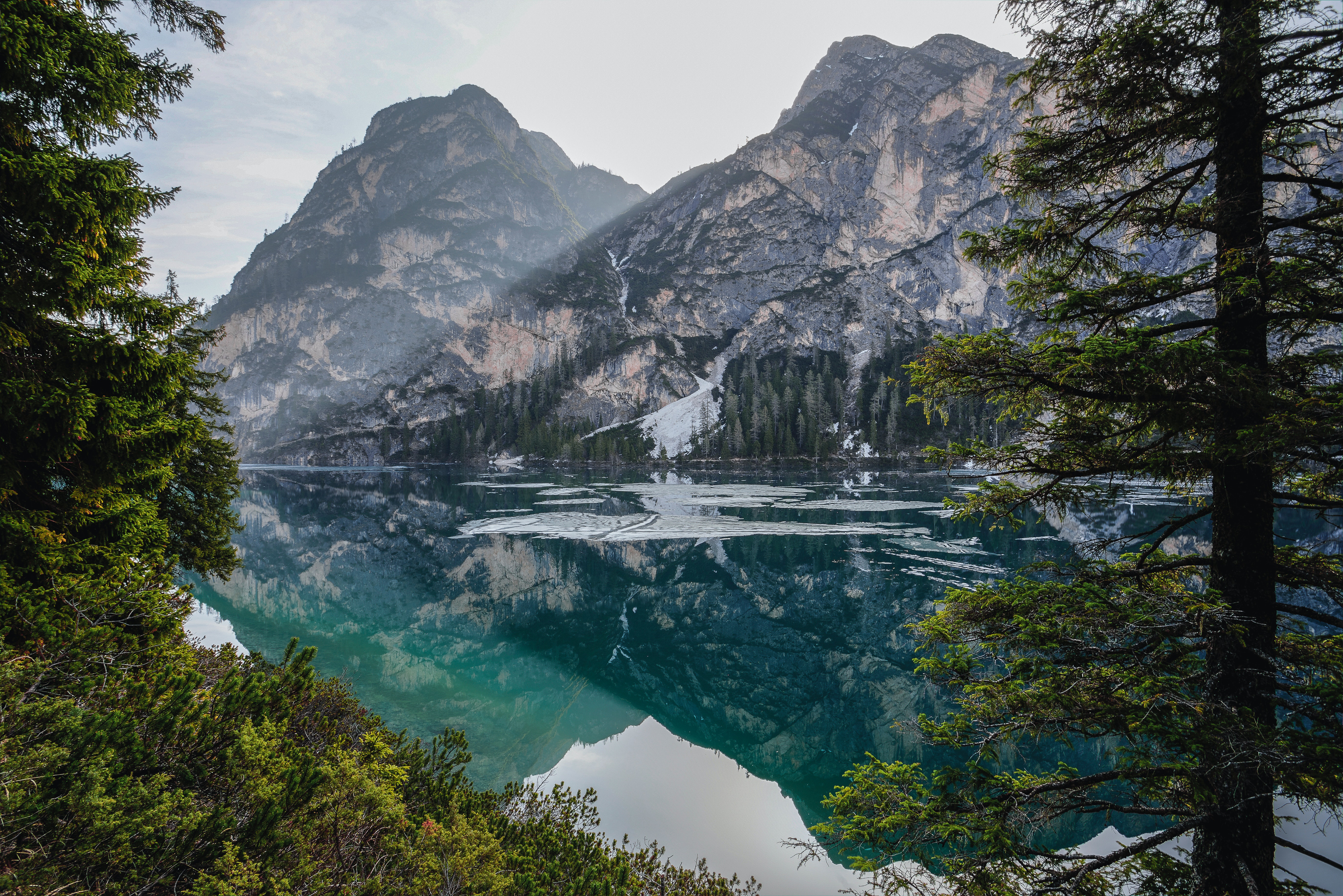 A landscape photo of mountains, trees, and a river flowing through